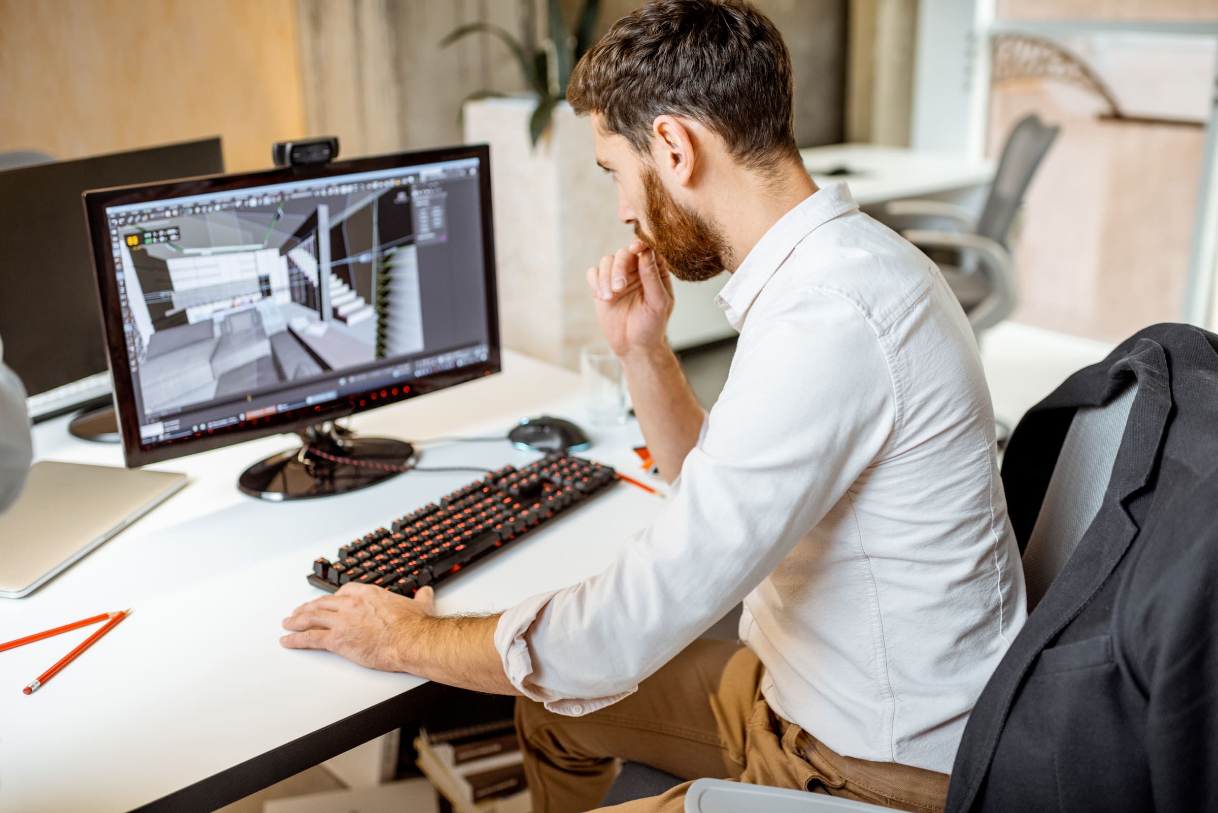 Projektant pracuje na 3D modeli na počítači v kancelárii