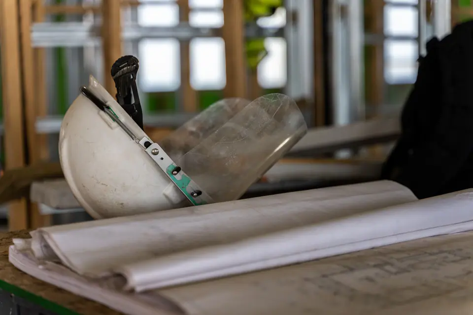A hard hat and building plans on a table